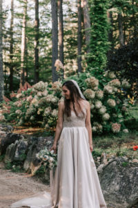 bride near flowers at lakeside wedding venue in new hampshire
