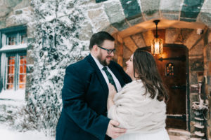bride and groom outside a gorgeous Fall River wedding venue in the snow, captured by Vivid Instincts Photography
