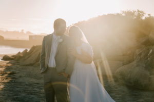 bride and groom posing for sunset portraits on the beach 