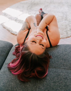 woman posing on floor during boudoir session with Ari Leo of Vivid Instincts Photography