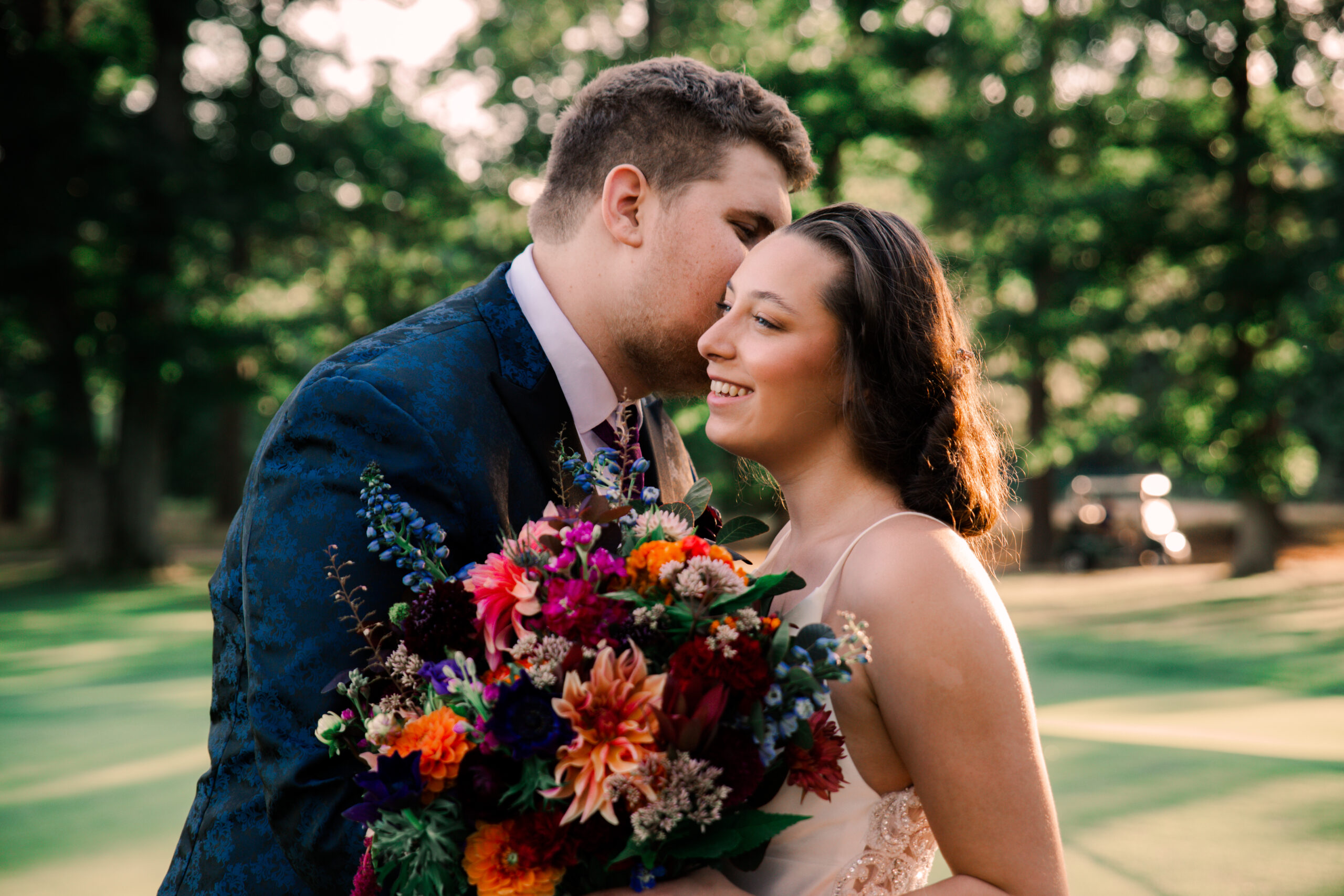 A couple getting married at Blue Hill Country Club in Canton, MA, posing with a colorful bouquet