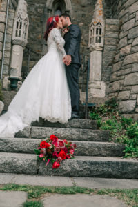 newly married couple posing for photos with bouquet on stone steps