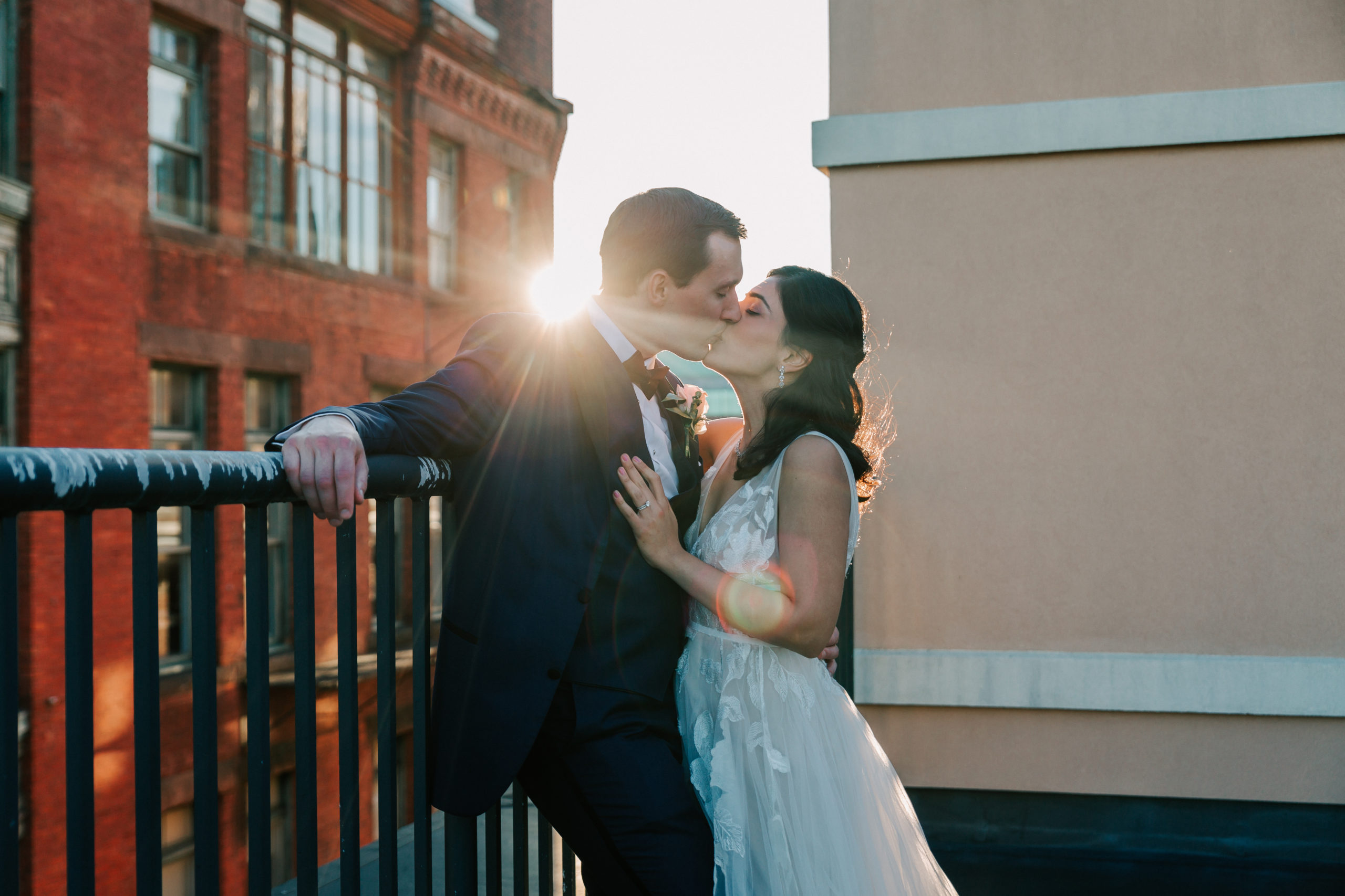bride and groom kissing at sunset on hotel roof at Providence, Rhode Island wedding venue