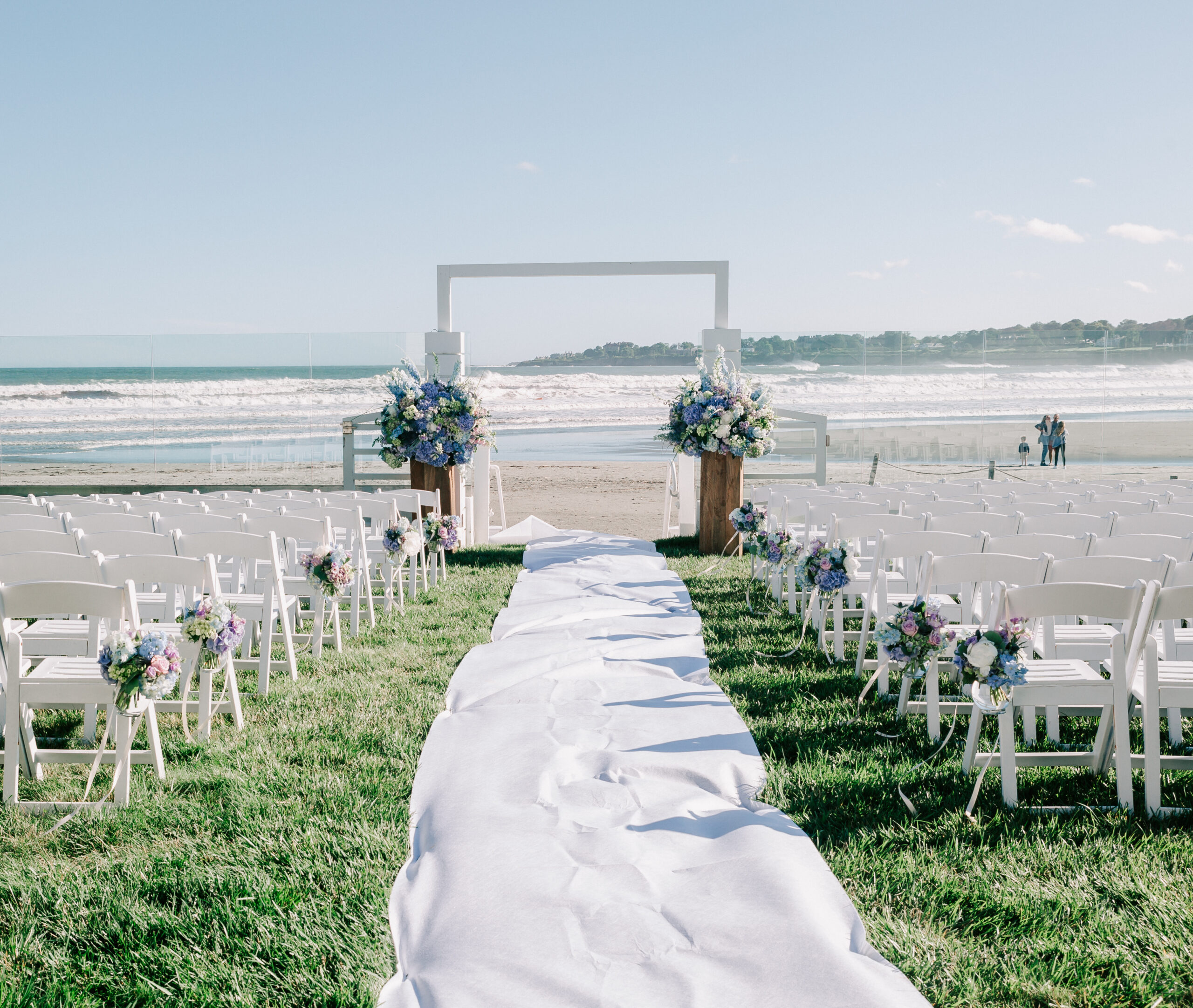 the front lawn of Newport Beach House, a gorgeous and unique wedding venue in Rhode Island, decorated for a summer ceremony