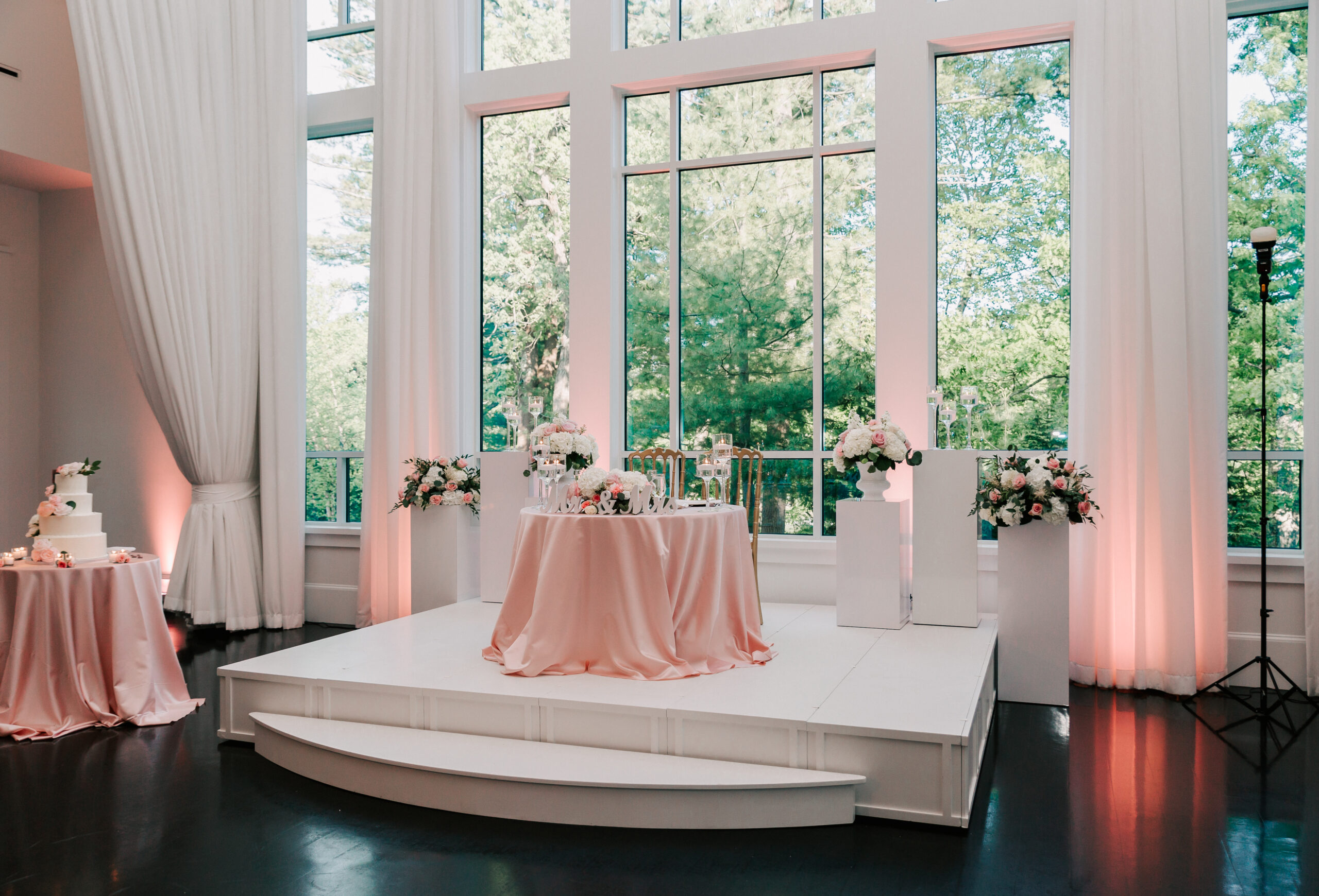 the stunning ballroom with floor-to-ceiling windows at Lakeview Pavilion in Foxboro, decorated for a wedding reception