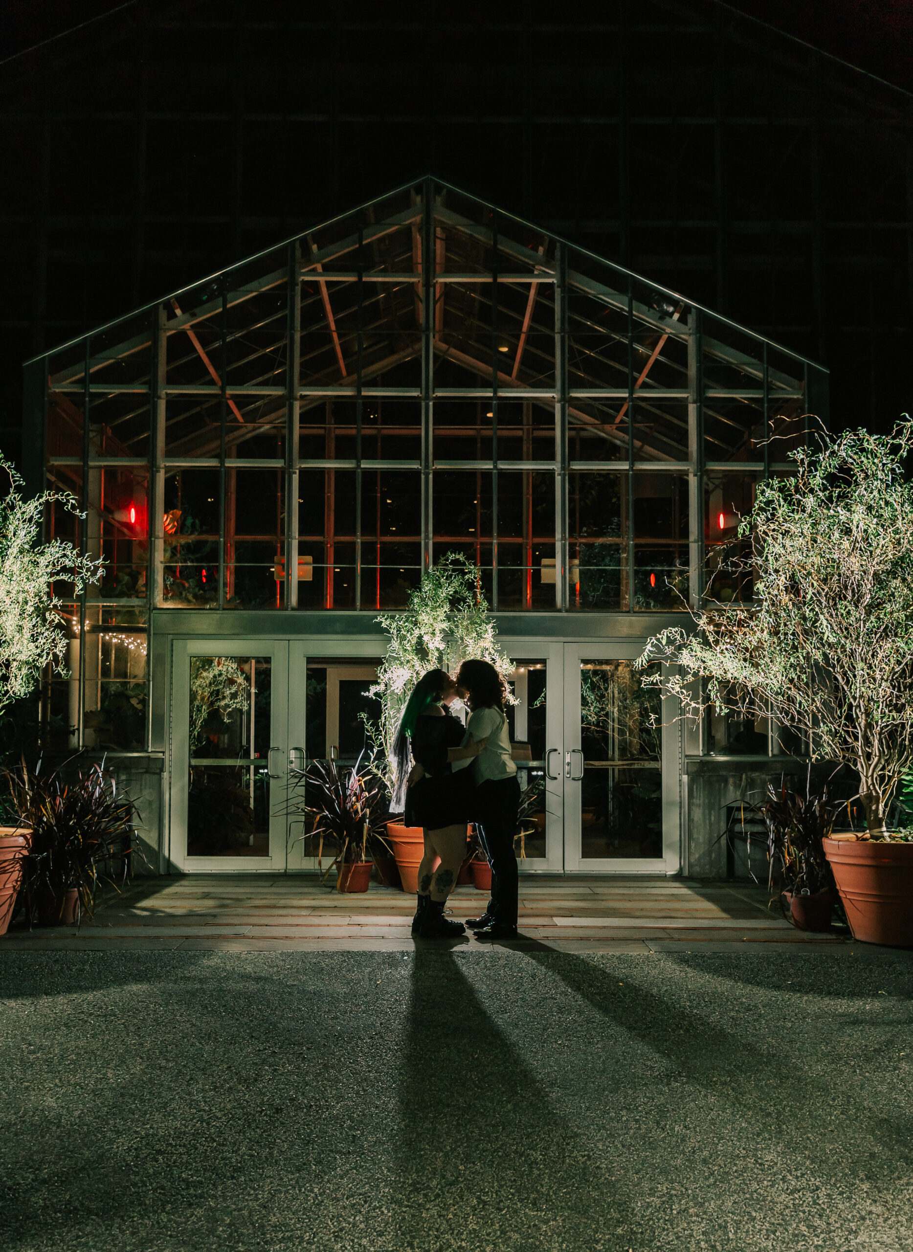 newly married couple posing for a night shot outside the greenhouse at Roger Williams Botanical Garden