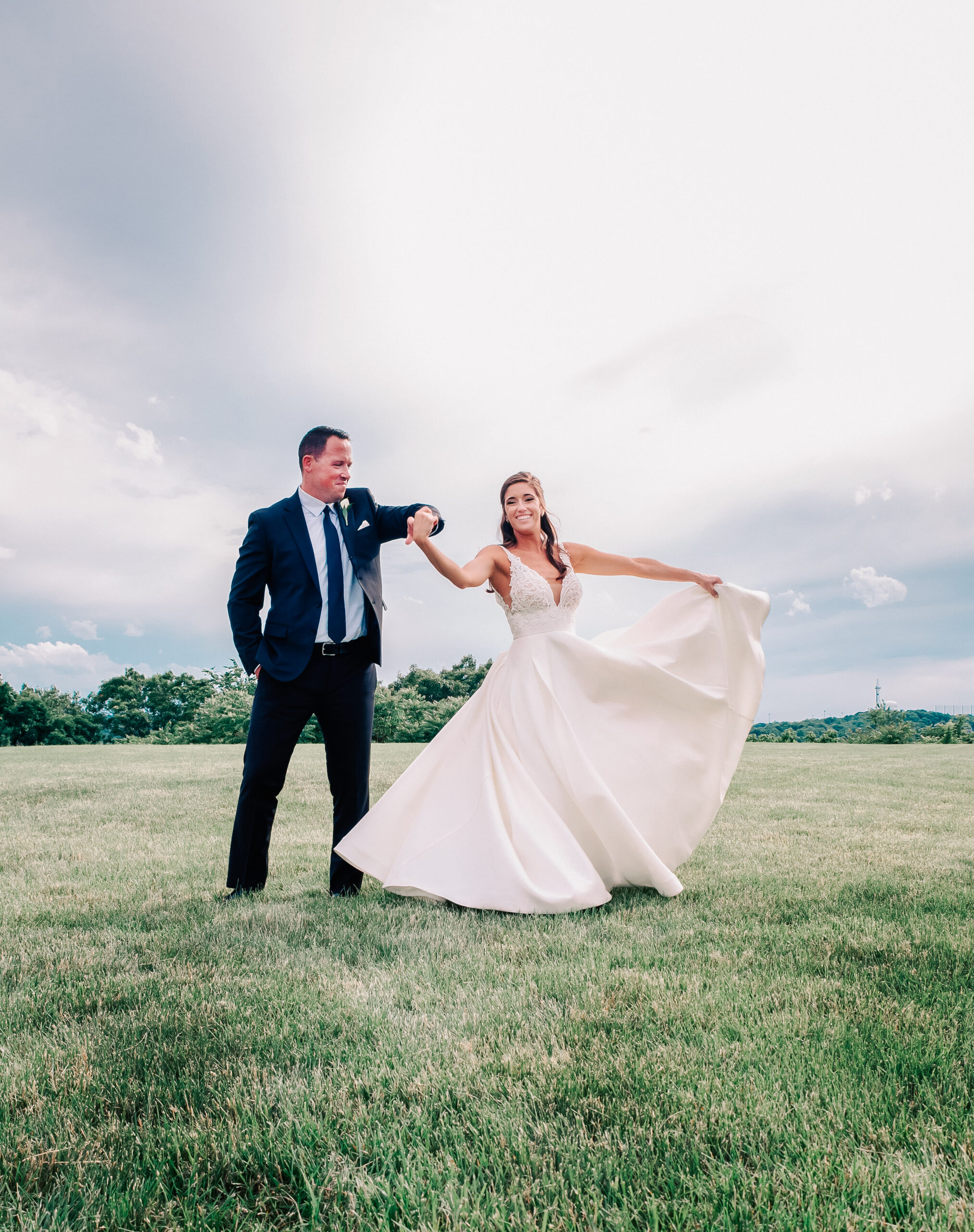 groom twirling bride on lawn at their Tirrell Room wedding