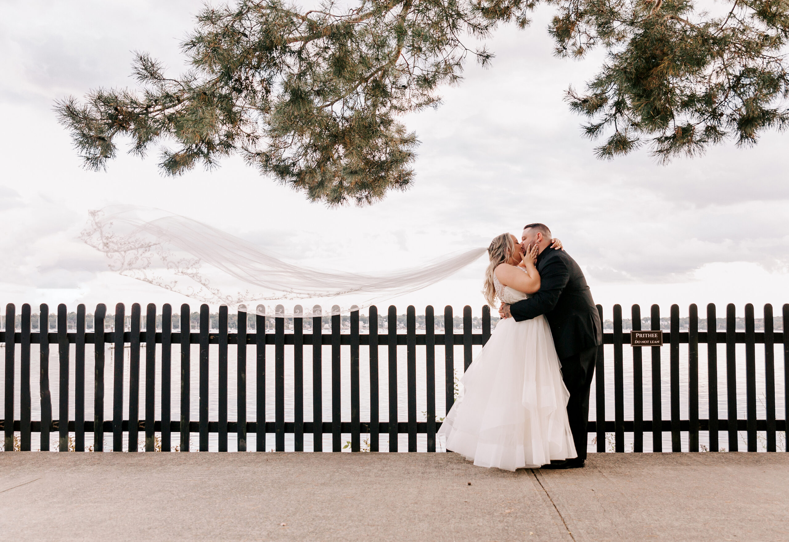 bride and groom kissing with veil flowing behind bride at House of Seven Gables, a Salem MA wedding venue