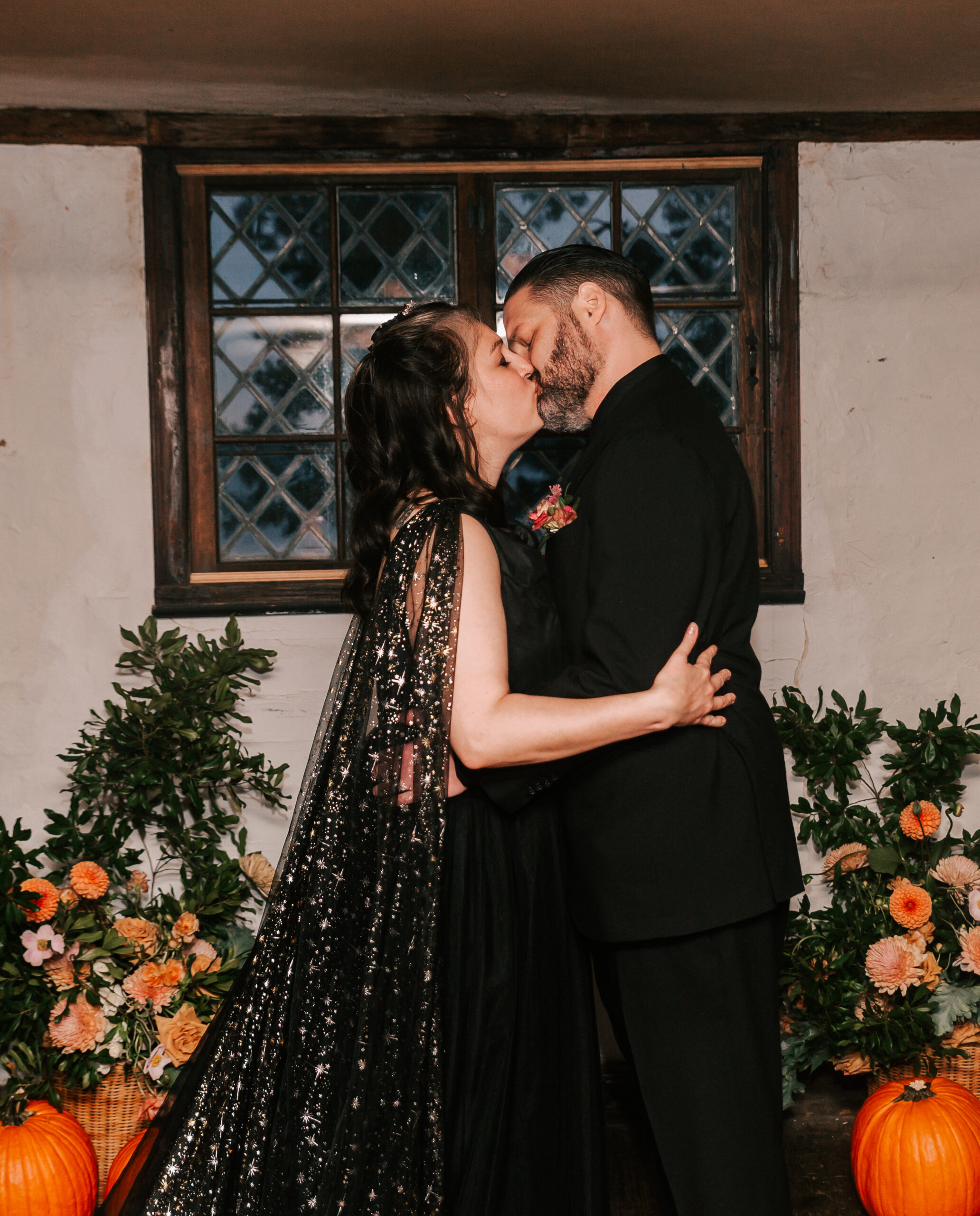 alternative couple in black attire kissing at wedding ceremony at a Salem MA wedding venue
