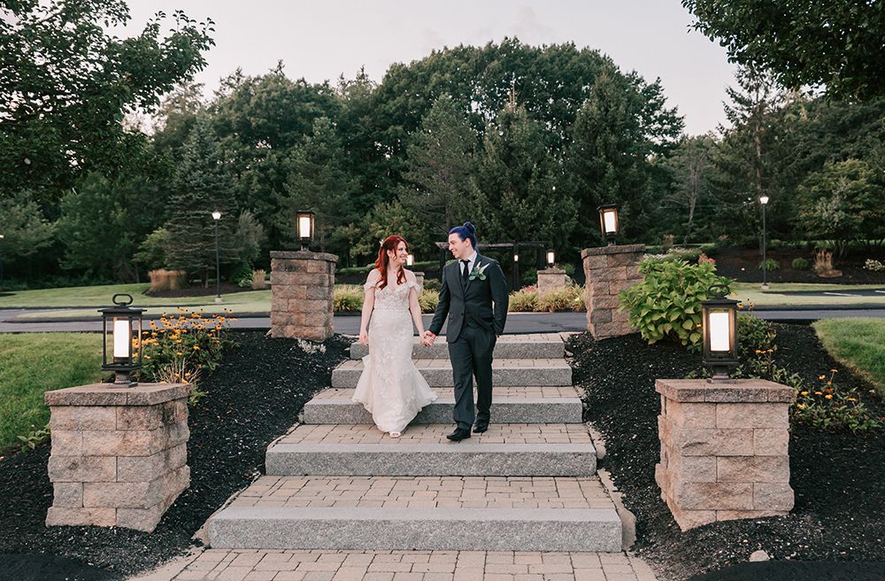 newlywed couple walking hand in hand down stone steps at the Colonial Hotel, a romantic wedding venue in Central MA
