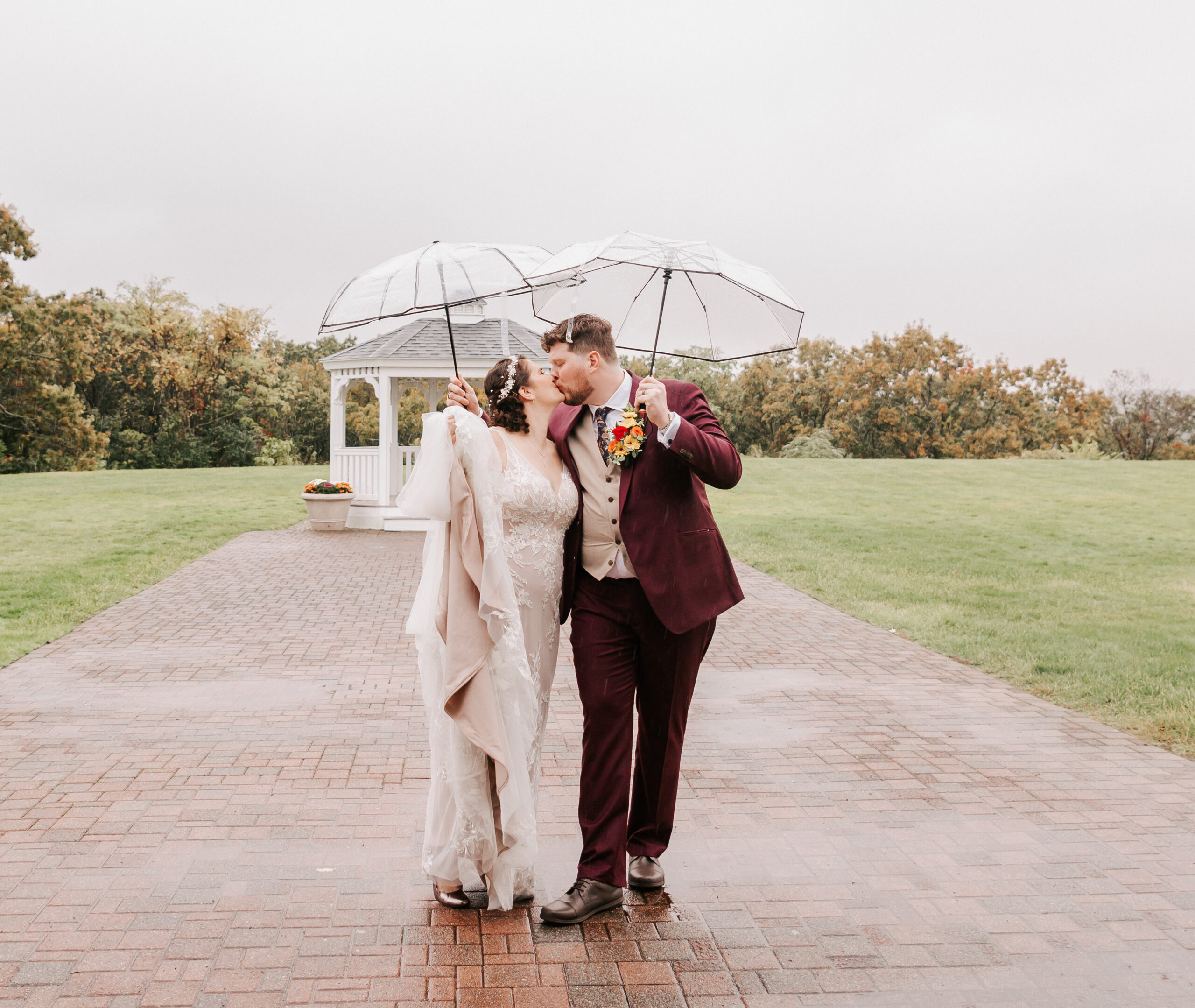 bride and groom walking down stone path in rain, wearing attire from a Boston wedding dress shop