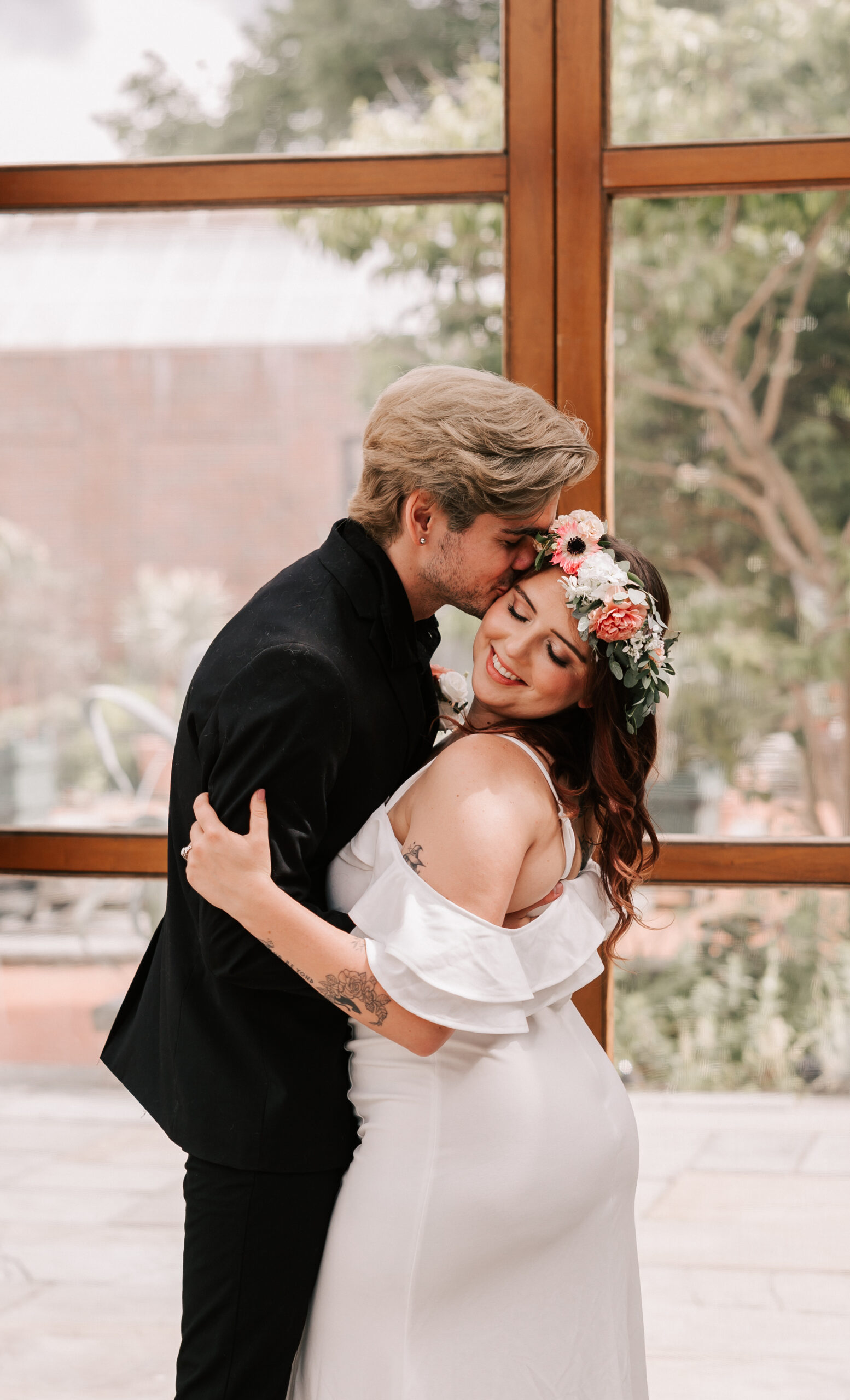 groom kissing bride on their wedding day in the Orangerie of Tower Hill Botanic Garden