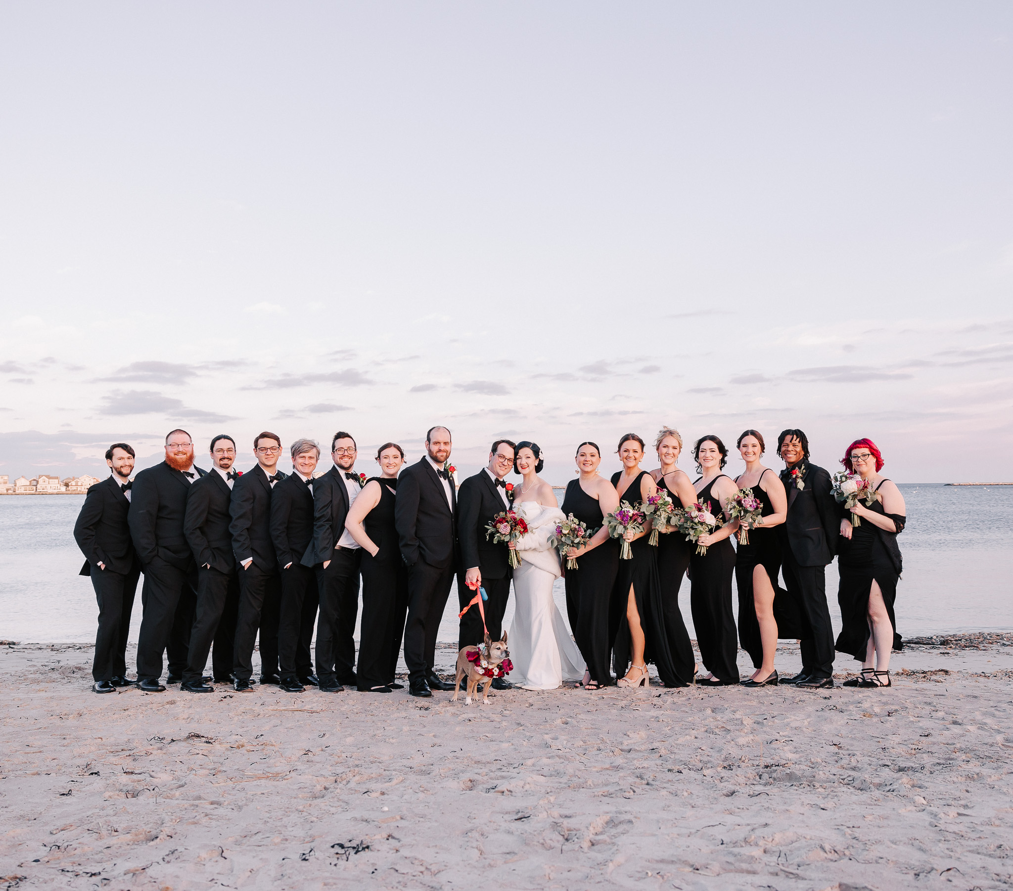 wedding party posing on beach near barker house in scituate, massachusetts