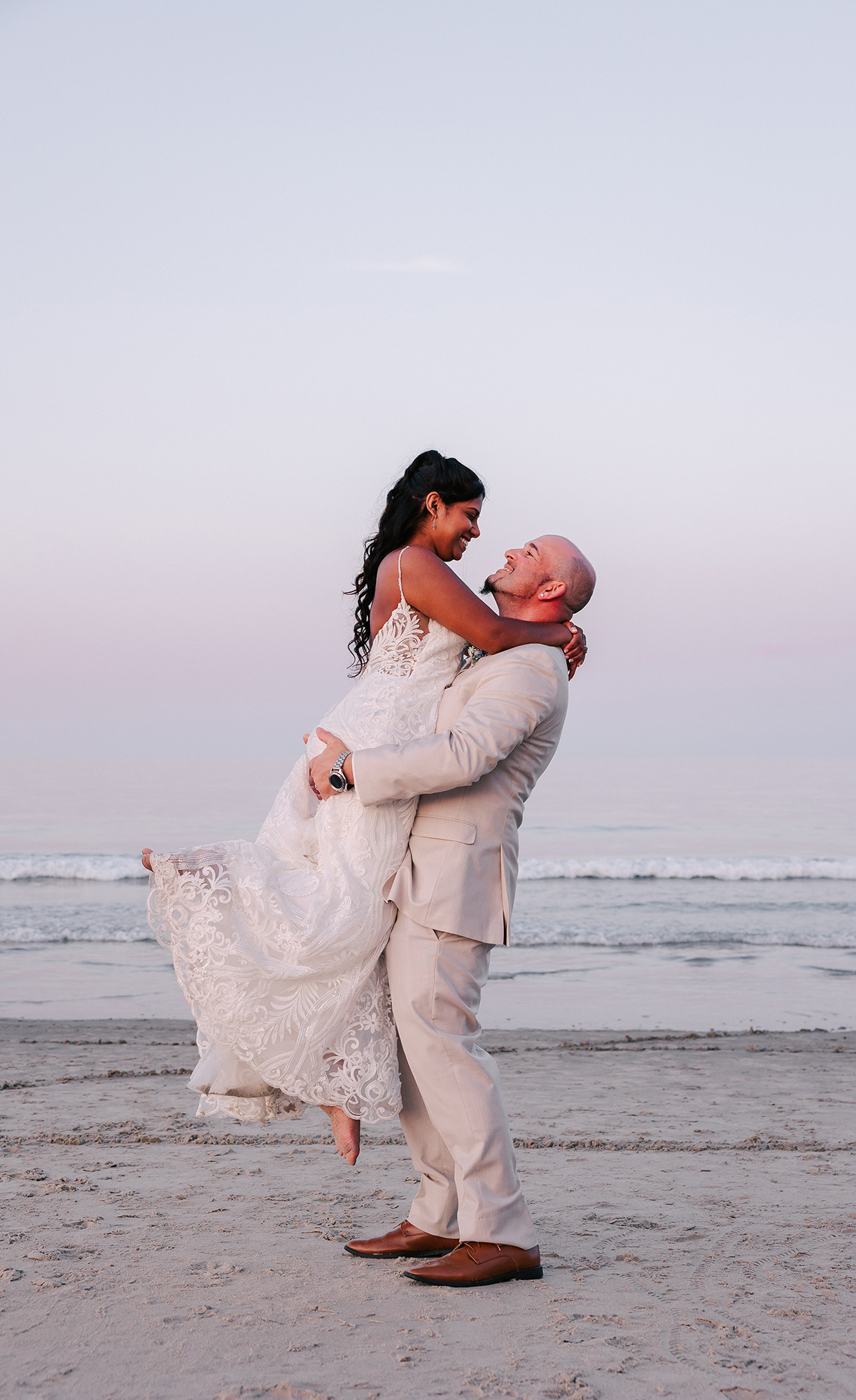 groom lifting bride on beach at sunset during wedding at a North Shore MA wedding venue