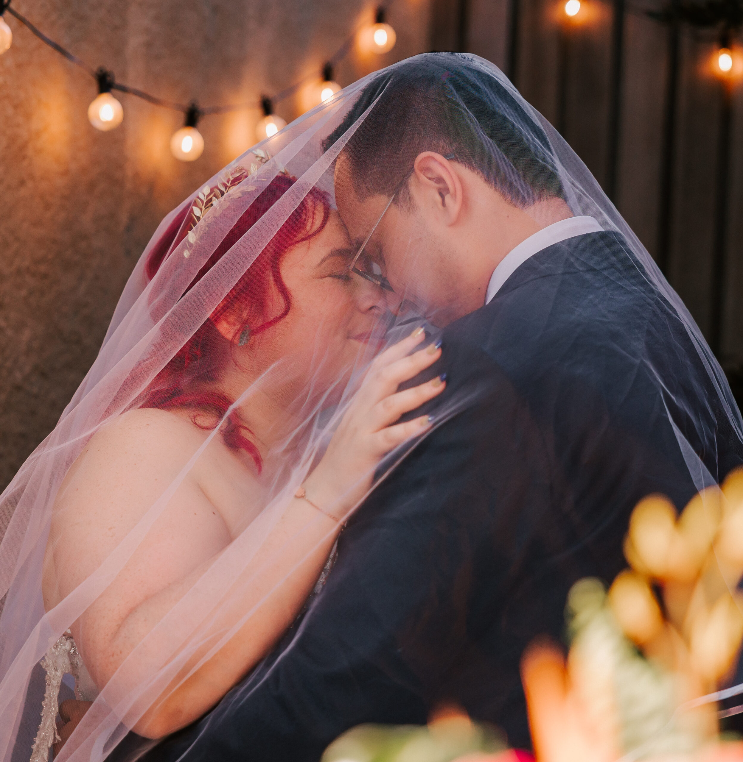 couple posing for photos under bride's veil at wedding reception at Spoke Wine Bar