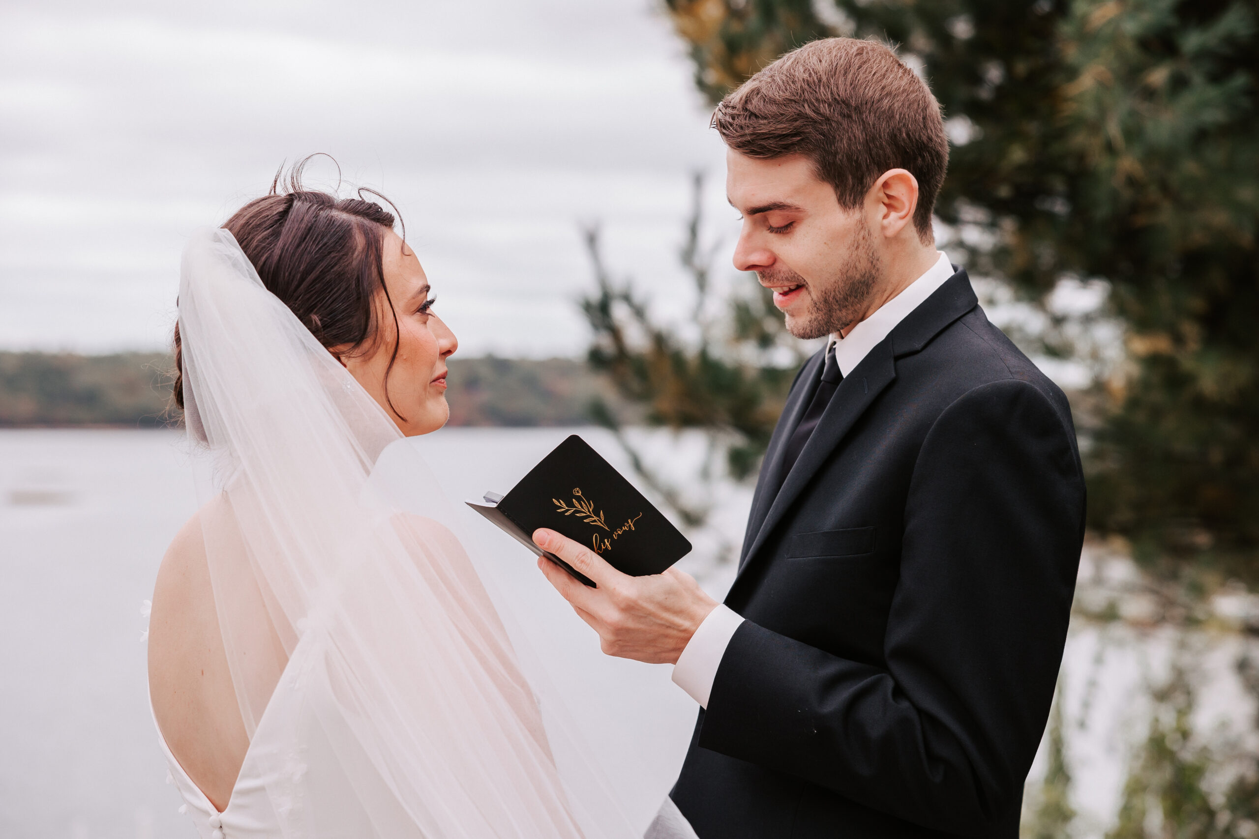 bride and groom reading private vows to each other by water at their backyard wedding in Westport, MA
