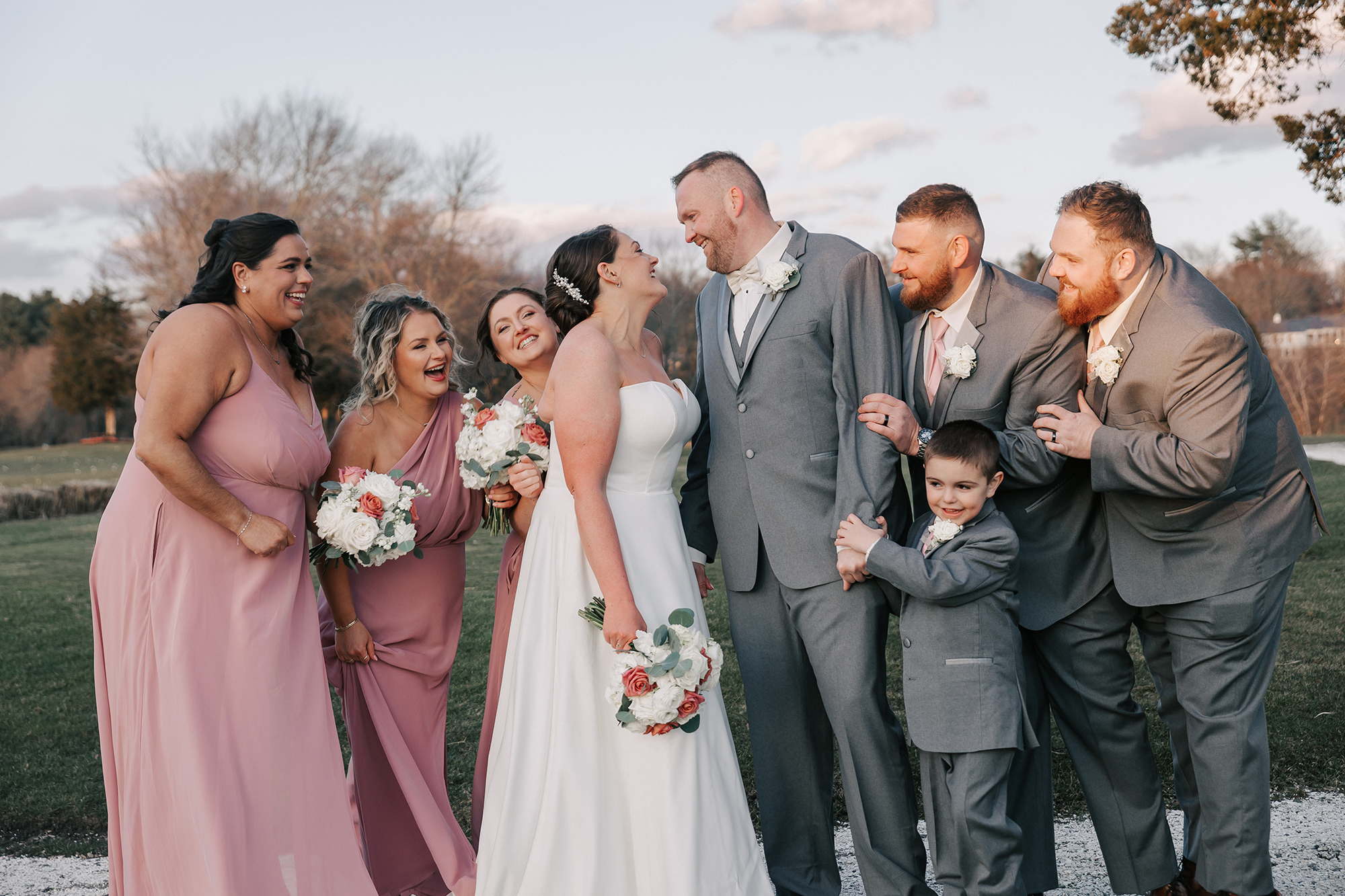 wedding party posing for fun photos on golf course at Harbor Lights