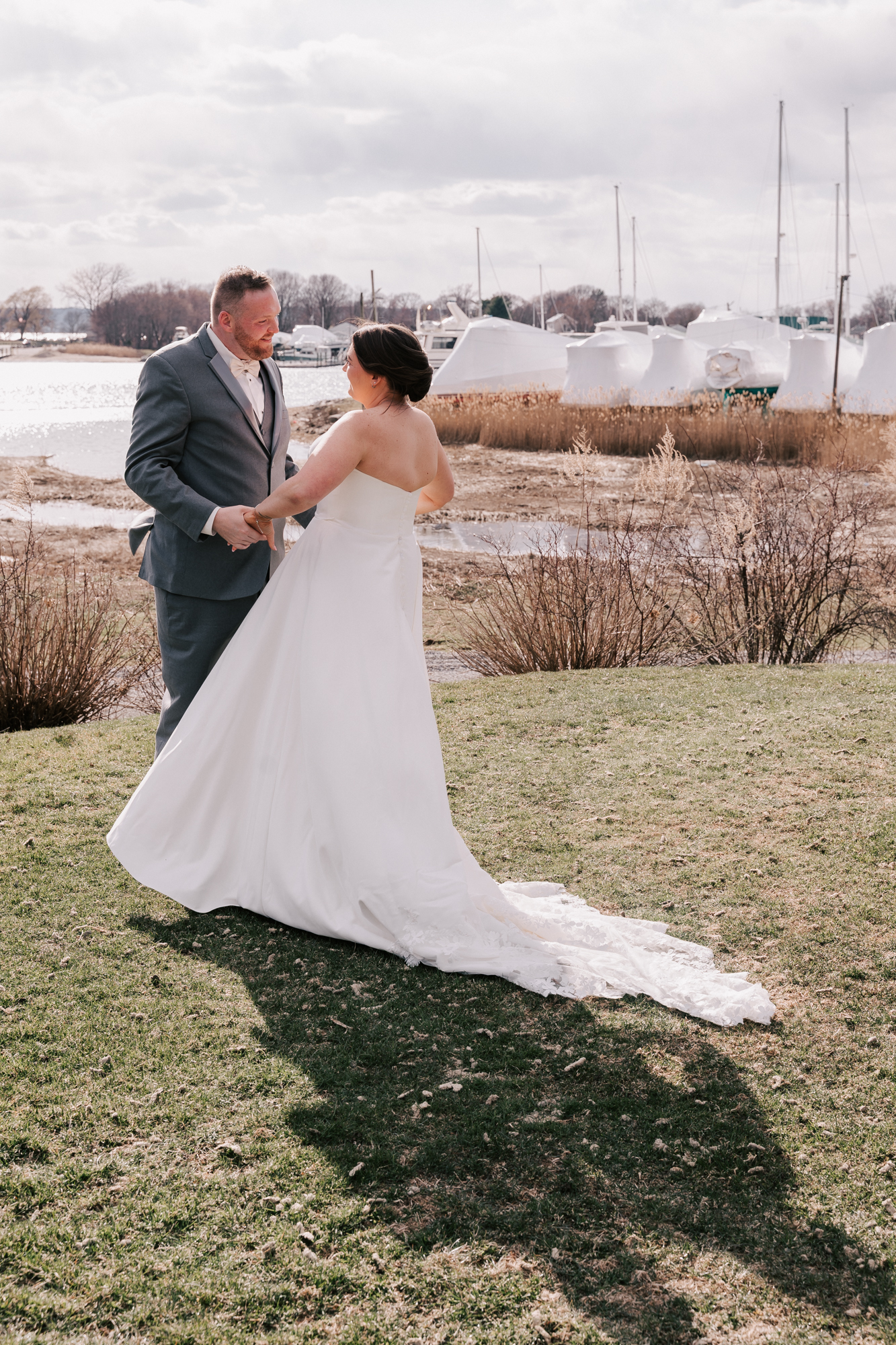 bride and groom sharing first look on waterfront lawn at Harbor Lights